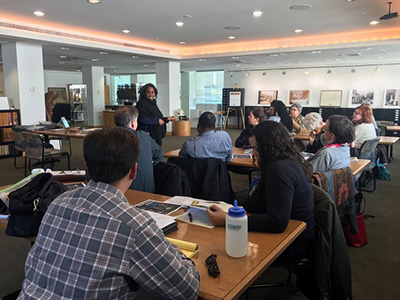 Woman standing in front of seated workshop participants.