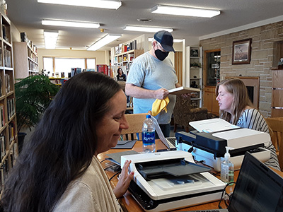 Staff using scanners to digitize state publications and references.