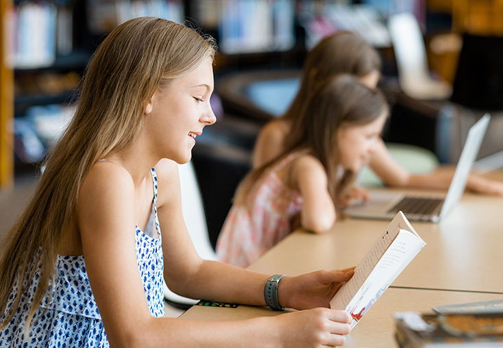 Girl reading book at a library