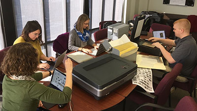 Reading Public Library patrons seated at desk with laptop and science project.