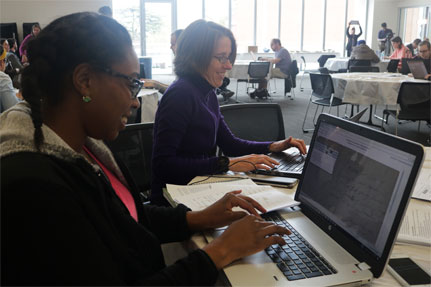 Woman and student in front of computer monitor