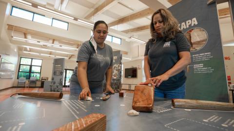 Kapa visitors pound clay (wauke) with an interactive display station.