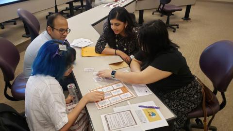 A group of library professionals seated at a table and working together.