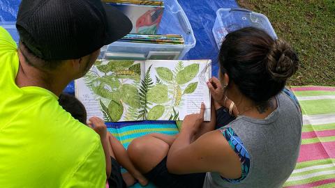 A parent and child reading a book together during Papaha Kuaola’s 2021 IMLS project (NH-250455OLS-21).